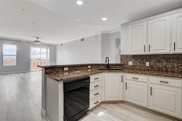 kitchen featuring sink, white cabinets, black dishwasher, light hardwood / wood-style flooring, and dark stone counters