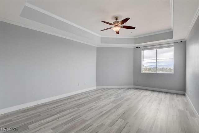 unfurnished room featuring ornamental molding, a raised ceiling, ceiling fan, and light hardwood / wood-style flooring