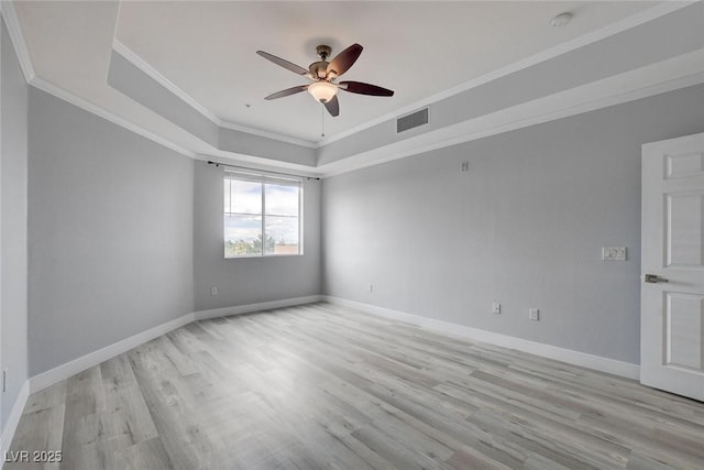 unfurnished room featuring ornamental molding, ceiling fan, a tray ceiling, and light hardwood / wood-style flooring