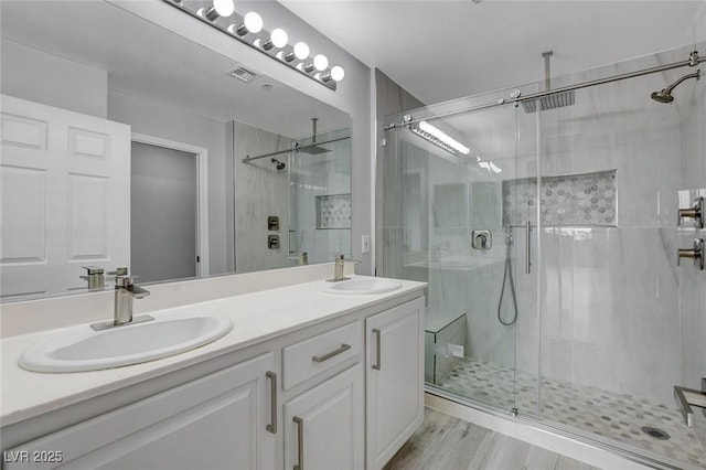 bathroom featuring vanity, a shower with shower door, and hardwood / wood-style flooring