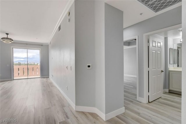 corridor featuring ornamental molding and light hardwood / wood-style flooring