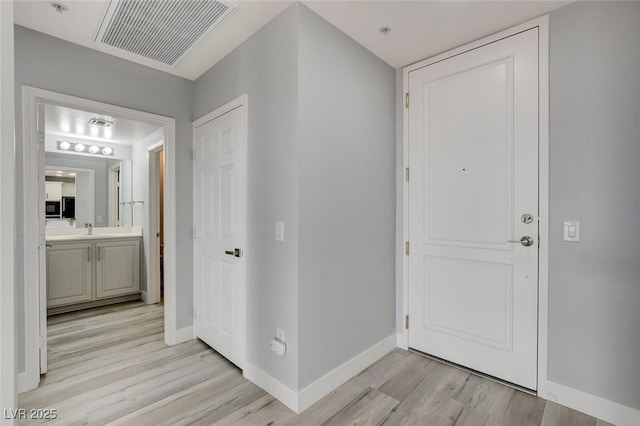 entrance foyer featuring sink and light hardwood / wood-style flooring