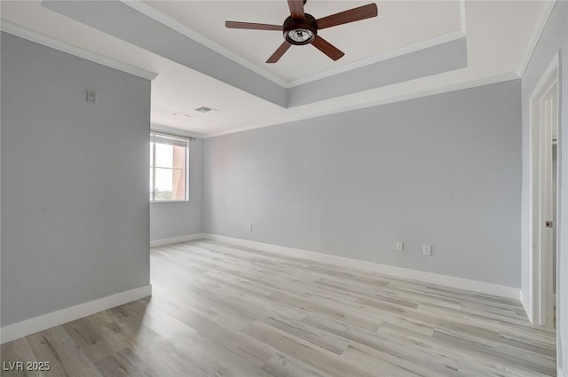 unfurnished room featuring crown molding, a raised ceiling, ceiling fan, and light hardwood / wood-style flooring