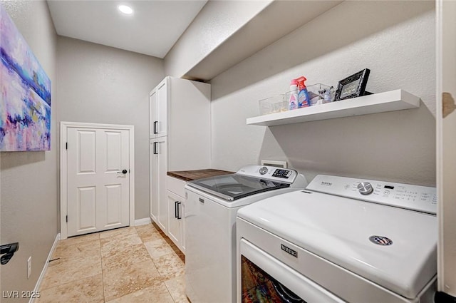 laundry area with washer and dryer and cabinets