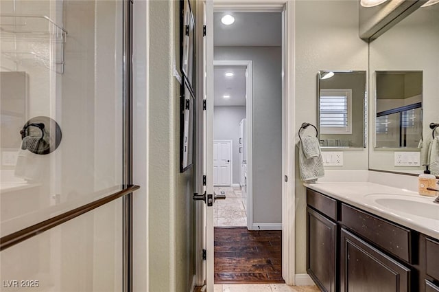 bathroom with hardwood / wood-style flooring, walk in shower, and vanity