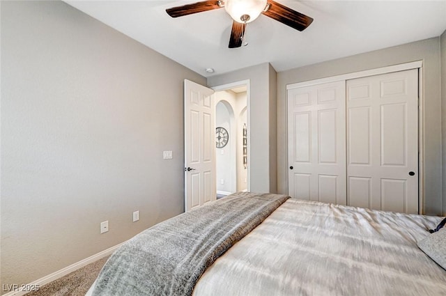 carpeted bedroom featuring ceiling fan and a closet