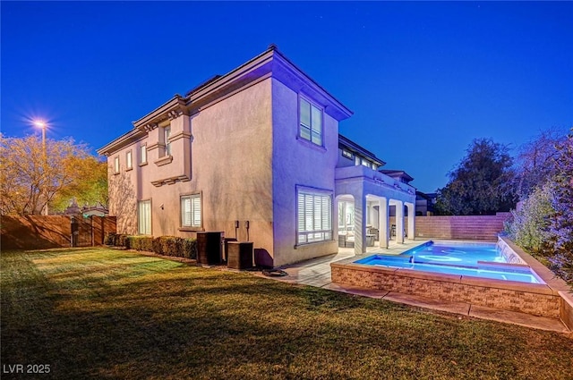 back of house featuring a fenced in pool and a lawn