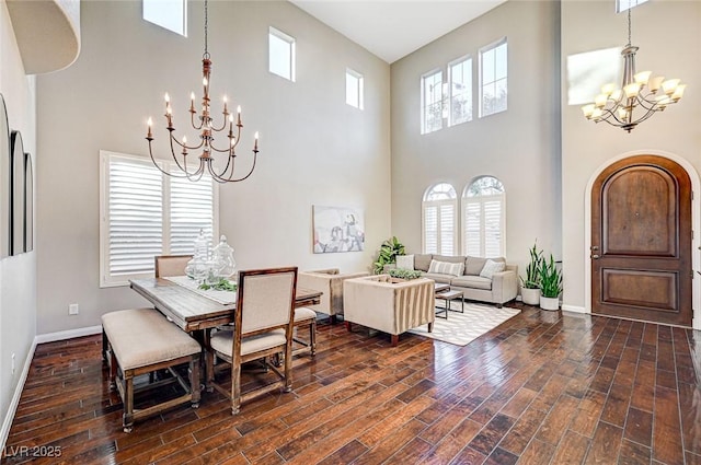 dining area with a towering ceiling and a chandelier