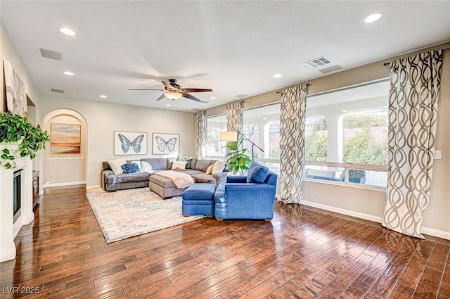 living room featuring ceiling fan and dark hardwood / wood-style flooring