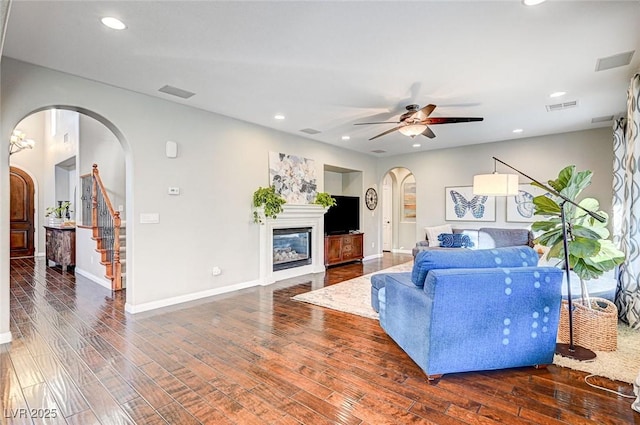 living room featuring ceiling fan and dark hardwood / wood-style flooring