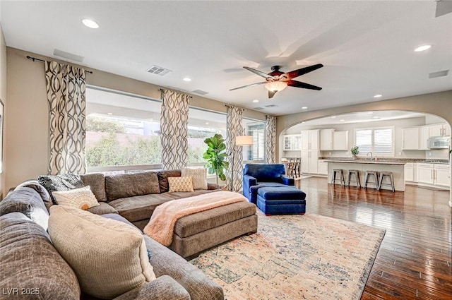 living room with ceiling fan, dark wood-type flooring, and sink