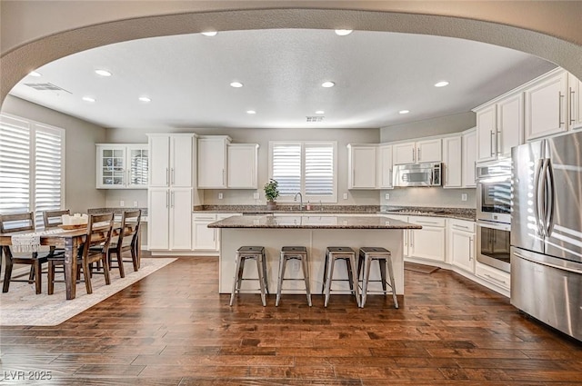 kitchen featuring a kitchen island, dark wood-type flooring, appliances with stainless steel finishes, and white cabinetry