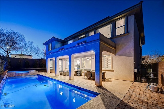 view of swimming pool with a patio, pool water feature, and an in ground hot tub