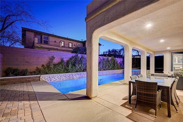 pool at dusk featuring a patio