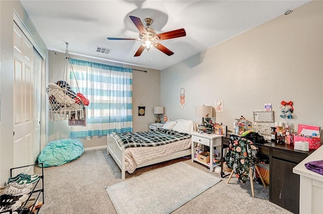 carpeted bedroom featuring ceiling fan and a closet