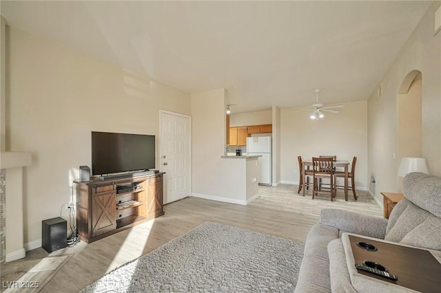 living room featuring ceiling fan and light hardwood / wood-style flooring