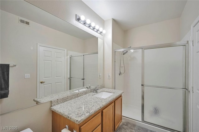 bathroom with a shower with door and vanity