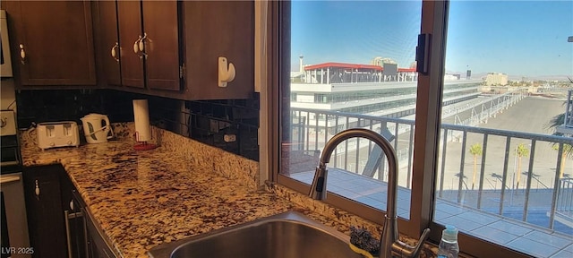 kitchen featuring a wealth of natural light, tasteful backsplash, and dark brown cabinetry