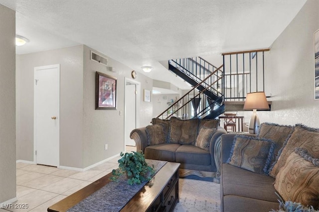 living room featuring a textured ceiling and light tile patterned floors