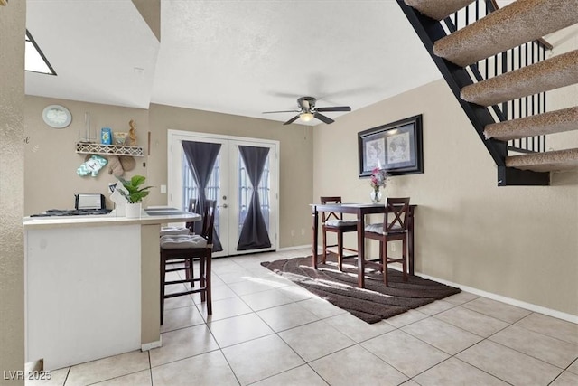 dining room featuring ceiling fan, french doors, and light tile patterned flooring