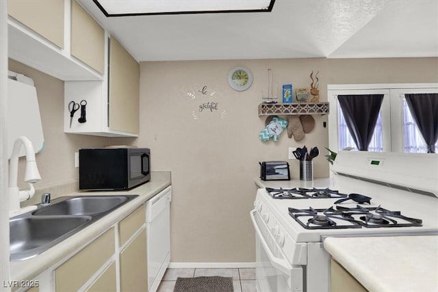 kitchen with white appliances, cream cabinets, light tile patterned flooring, and a textured ceiling