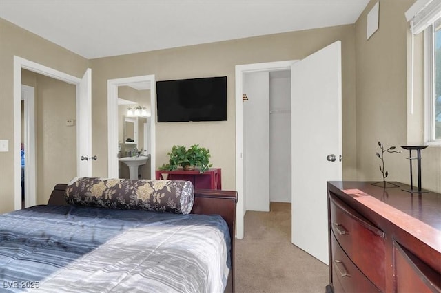 carpeted bedroom featuring sink and connected bathroom