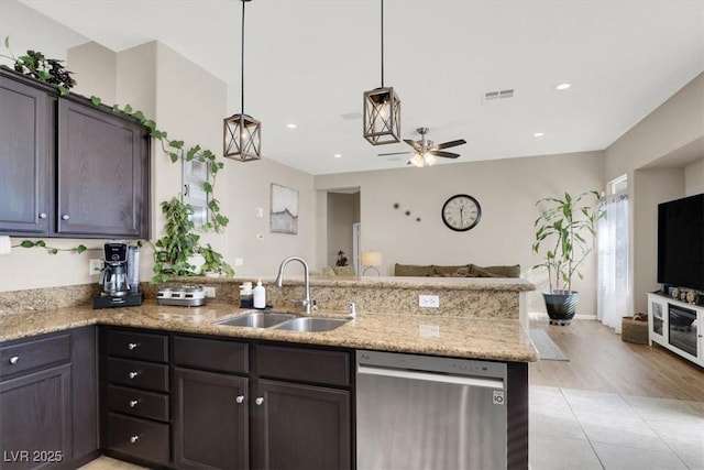 kitchen with kitchen peninsula, stainless steel dishwasher, pendant lighting, dark brown cabinets, and sink