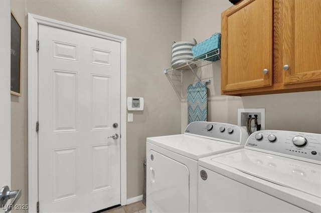 clothes washing area featuring washer and clothes dryer and cabinets