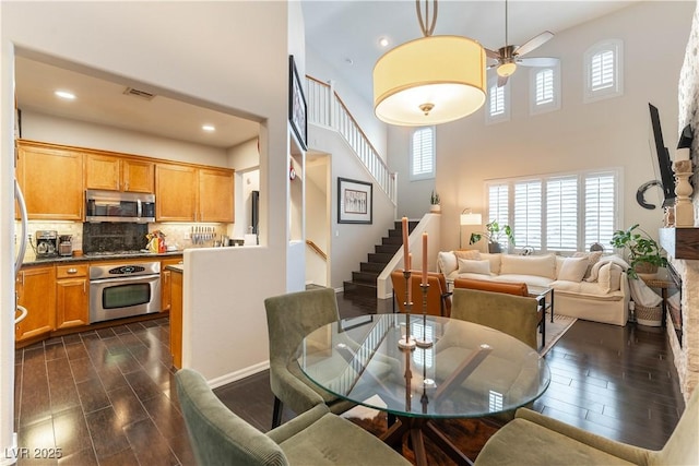 dining space with a high ceiling and ceiling fan