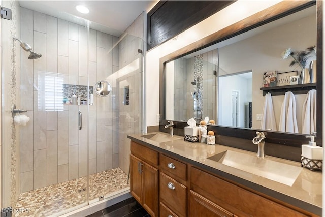 bathroom featuring tile patterned flooring, a shower with shower door, and vanity