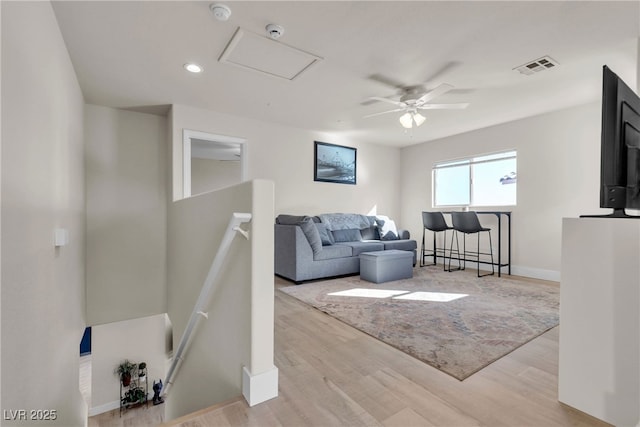 living room with light wood-type flooring and ceiling fan