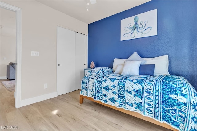 bedroom featuring ceiling fan, a closet, and hardwood / wood-style flooring