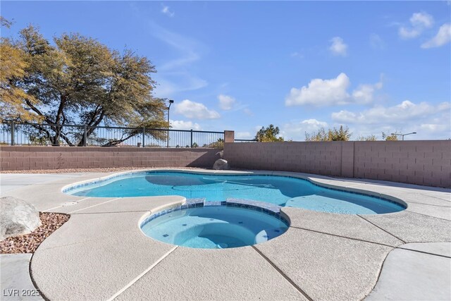 view of pool with an in ground hot tub