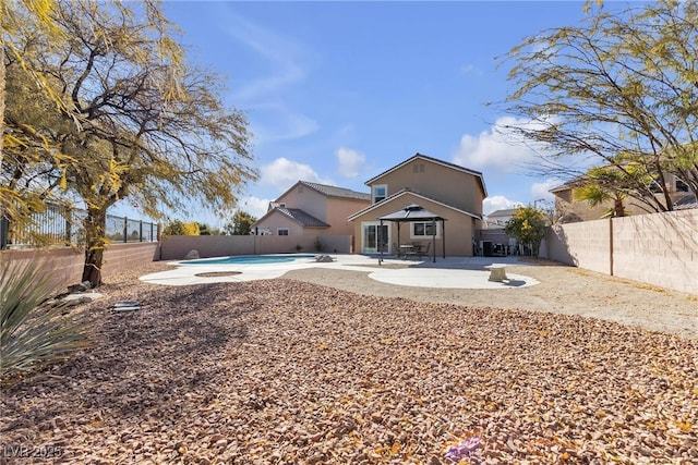 rear view of property with a patio and a fenced in pool