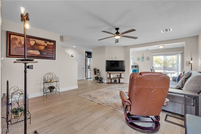 living room featuring ceiling fan and light hardwood / wood-style flooring