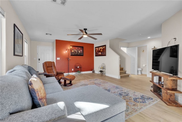 living room featuring ceiling fan and light hardwood / wood-style floors