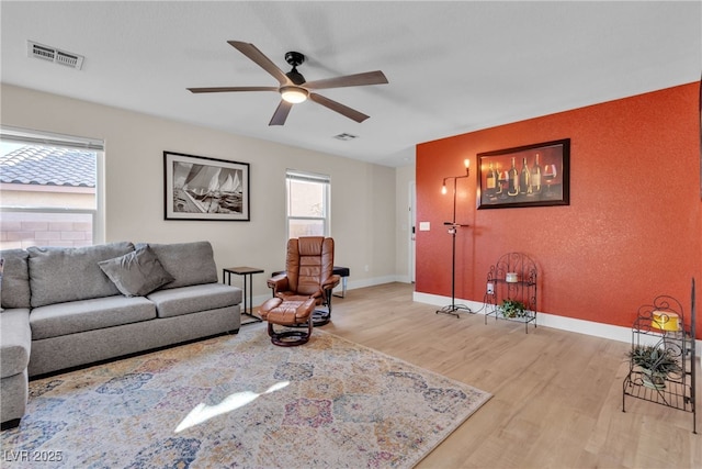 living room with ceiling fan, light hardwood / wood-style flooring, and a healthy amount of sunlight