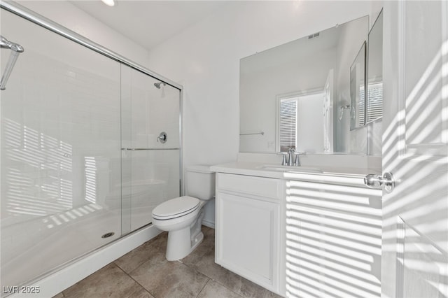 bathroom with toilet, a shower with door, vanity, and tile patterned flooring