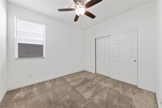 unfurnished bedroom featuring a closet, ceiling fan, and light colored carpet