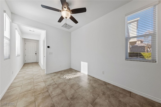 tiled empty room featuring ceiling fan and a healthy amount of sunlight