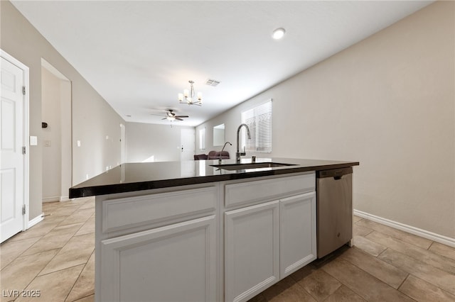 kitchen featuring stainless steel dishwasher, an island with sink, white cabinetry, ceiling fan with notable chandelier, and sink