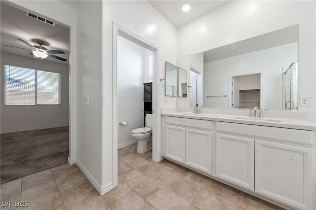 bathroom with toilet, ceiling fan, and vanity