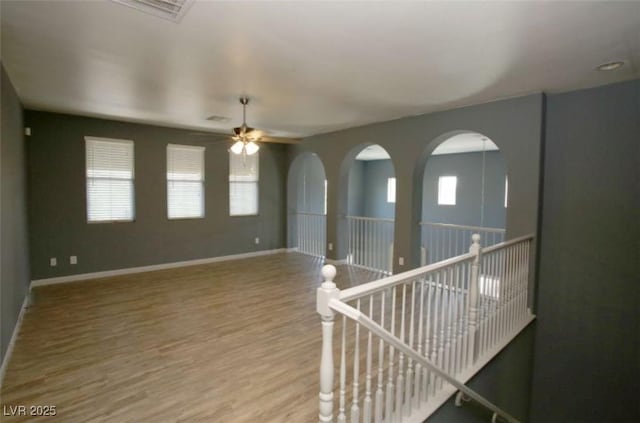 unfurnished room with ceiling fan and hardwood / wood-style flooring