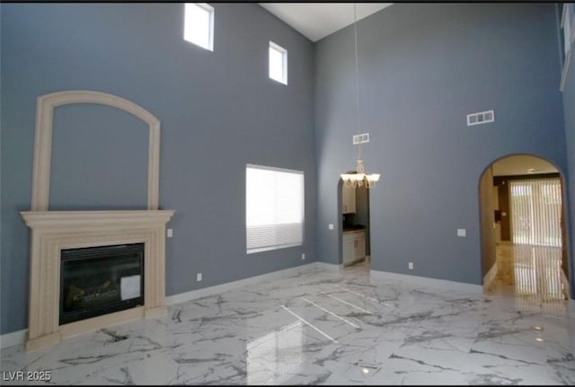 unfurnished living room featuring a towering ceiling