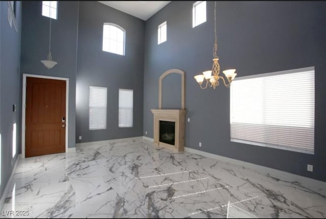 unfurnished living room with a high ceiling and an inviting chandelier