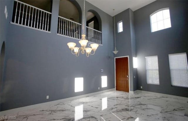 spare room featuring a high ceiling and a chandelier