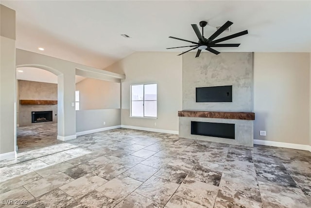 unfurnished living room with a fireplace, ceiling fan, and vaulted ceiling