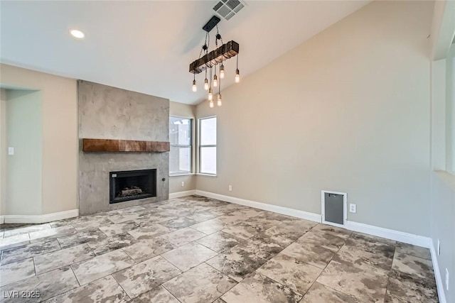 unfurnished living room with a large fireplace and lofted ceiling