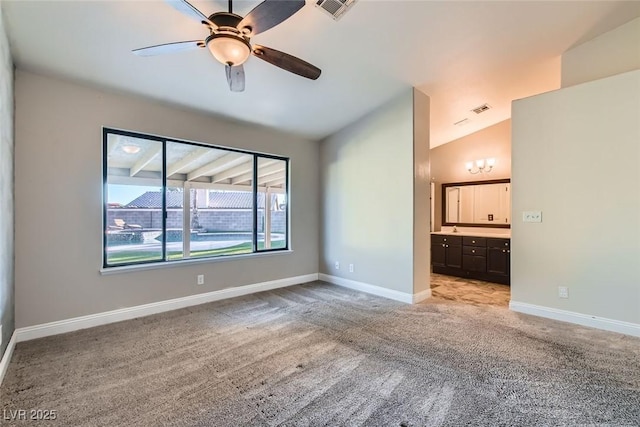 spare room featuring ceiling fan, light colored carpet, and vaulted ceiling