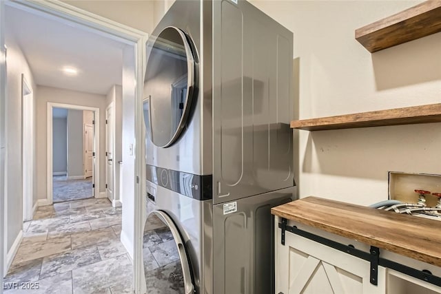 washroom featuring stacked washing maching and dryer